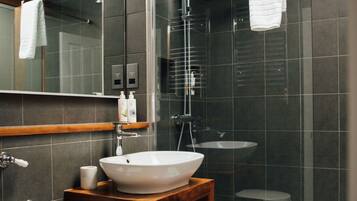 Ein modernes Badezimmer mit Oberlicht, einer freistehenden Badewanne, einem Waschtisch und einer Toilette.