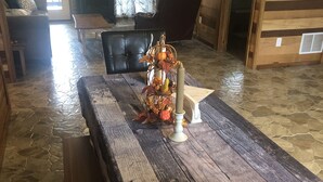 A rustic dining area with a wooden table, benches, and a decorative centerpiece. - Country Home with Pond and Great Outdoor Space (Nashport)