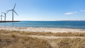 A beach with wind turbines in the background. - Cozy home in Ebeltoft (Ebeltoft)