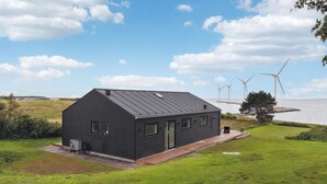 A modern black house with a sloped roof, a small porch, and a grassy yard. - Cozy home in Ebeltoft (Ebeltoft)