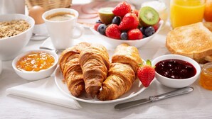 A breakfast setting with croissants, fruits, and beverages. - Samay Business Hotel  (Cusco)