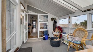 A cozy room with a dining area, a large window with a view, and a door leading to another room.