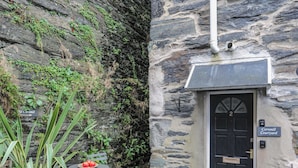A stone building with a black door labeled "Cornmill Courtyard." - Cornhill Courtyard (Porthmadog)