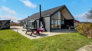 Una casa moderna con un amplio patio, una chimenea y un comedor.