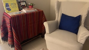 A room with a striped table covered with books and a small potted plant. - Doreen Gem (Doreen)