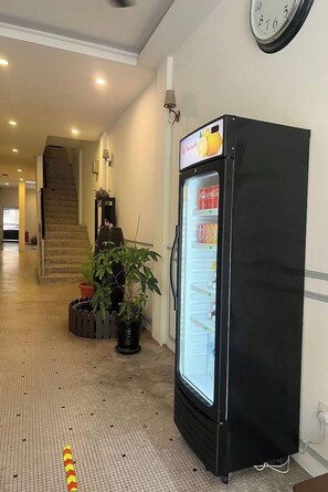 A hallway with a vending machine, a staircase, and a potted plant. - M S Hotel Tengku Kelana KTM Klang (Klang)