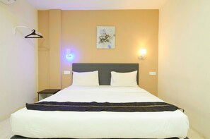 A neatly made bed with white linens and a dark blanket, a wall-mounted light fixture, and a simple artwork on the wall. - M S Hotel Tengku Kelana KTM Klang (Klang)