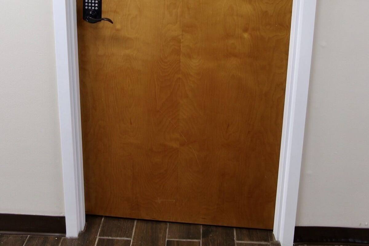 Une porte en bois portant le numéro « 4 », un interphone et un cadre blanc.