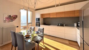 Une cuisine moderne avec des armoires blanches, un four encastré et un grand îlot central.