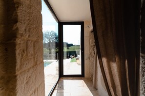 Un intérieur moderne avec une grande porte vitrée donnant sur un espace extérieur.