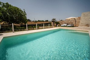 A clear swimming pool with a stone wall and a rope barrier. - WePuglia - Trullo Meraviglioso (Martina Franca)