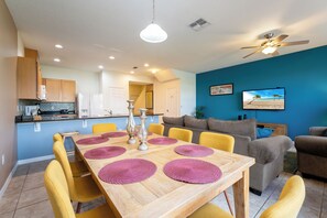 A modern living space with a dining area, kitchen, and seating area.