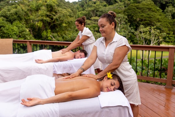 A spa setting with three massage tables, each with a person receiving a massage.