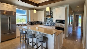 A modern kitchen with a large island, stainless steel appliances, and pendant lighting. - Two Bedroom Luxury Condo located in Beautiful February Point (George Town)