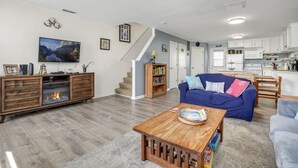Ein modernes Wohnzimmer mit Kamin, einem blauen Sofa und einem Holztisch.