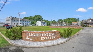 Ein Schild für Lighthouse Estates mit einer Ziegelbasis und weißer Schrift.