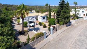 Zona residencial com casas, um carro e vista desobstruída para o litoral.
