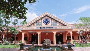 A building with a central fountain, a sign reading "DAI NAM THAI Y VIEN", and traditional architectural elements. - Spatel d'Annam Boutique Spa & Hotel (Hue)