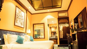 A hotel room with a bed, a large framed picture, a mirror, a wardrobe, and a television. - Spatel d'Annam Boutique Spa & Hotel (Hue)
