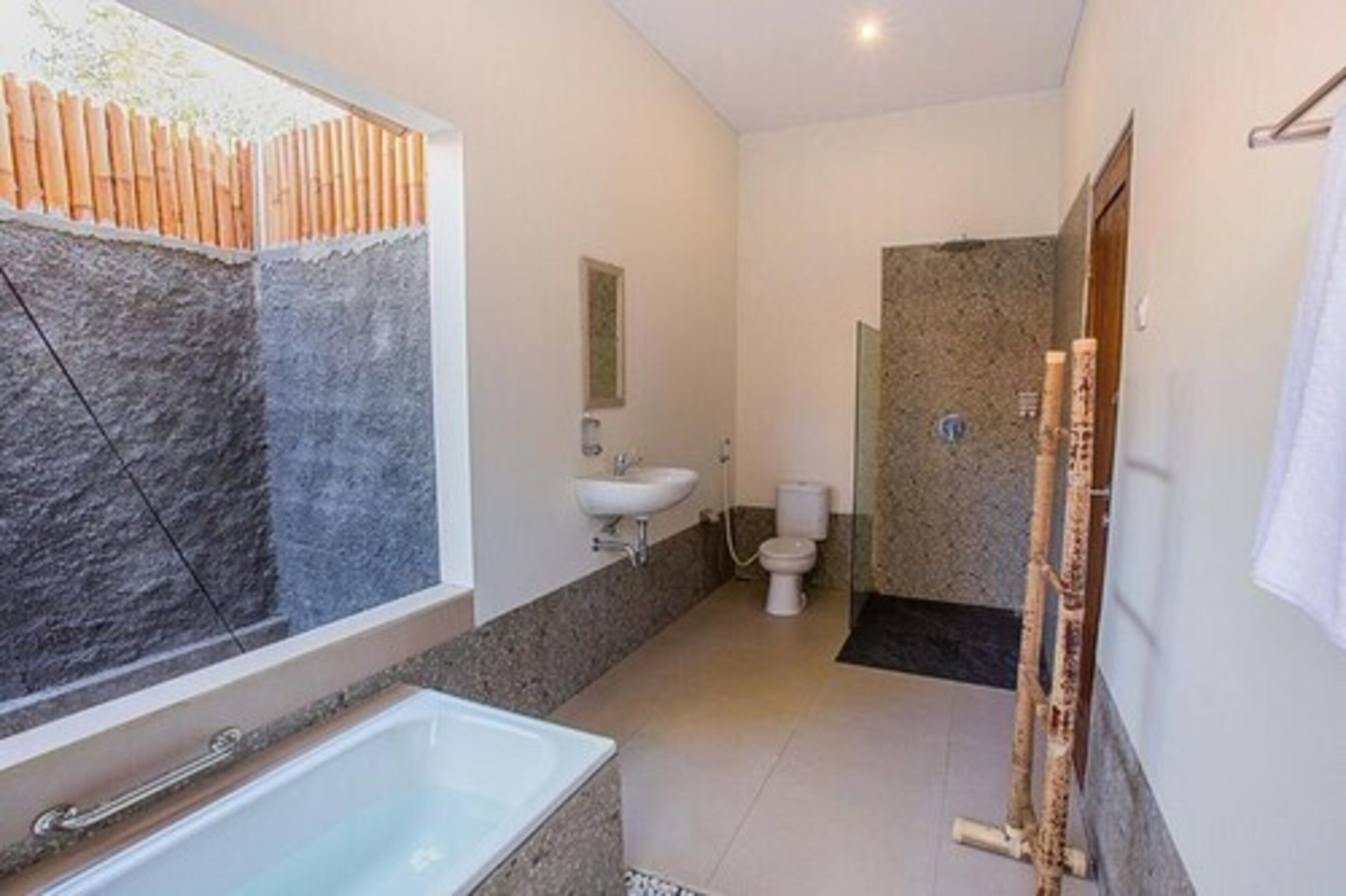 A modern bathroom with a bathtub, sink, and toilet.