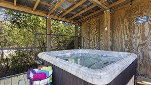 A hot tub with a wooden deck and a metal railing. - Vibrant & Enchanting! Hot Tub! Walk to the Beach! (Pass Christian)