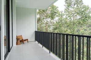 A balcony with a wooden bench, a black railing, and a view of trees. - Lavender Rooftop 3BR Villa with a Heated Private Pool (Cimenyan)
