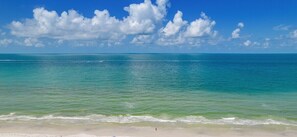 Une plage à l’eau turquoise et limpide, bordée d’un rivage sablonneux.