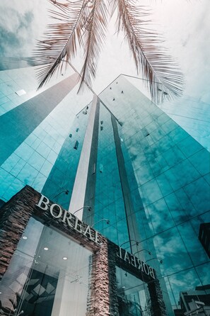 A modern building with a glass facade and the name "BORA HOTEL" visible on the entrance. - OLYMPUS APARTMENTS (Quito)