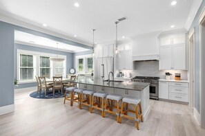 Enjoy cooking in this well-equipped kitchen with a central island, stainless steel appliances, and a large window.