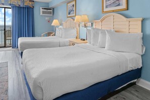 A hotel room with two beds, a view of the sea, a balcony, and a large window.