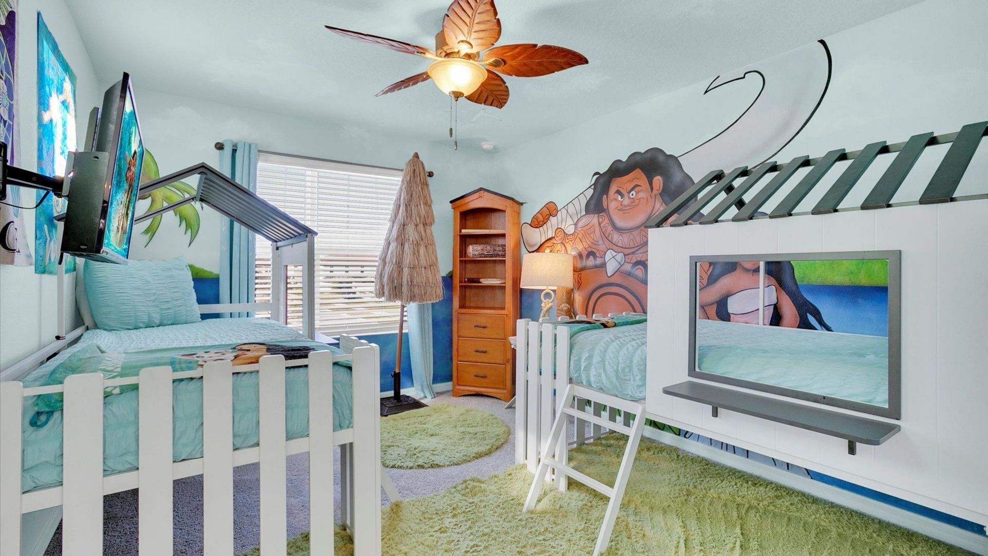 A child's bedroom with bunk beds, a ceiling fan, a mural, and a TV.