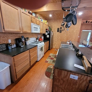 Enjoy cooking in this well-equipped kitchen with a central island, sink, microwave, stove, and refrigerator.