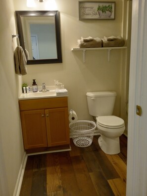 Enjoy a refreshing bathroom experience with a vanity, mirror, toilet, and storage basket.