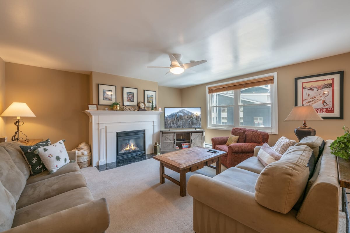 A cozy living room with a fireplace, comfortable seating, and a television.
