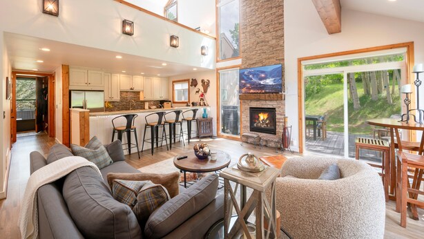 A spacious living area with a fireplace, a dining area, and a kitchen.