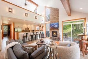 A spacious living area with a fireplace, a dining area, and a kitchen.