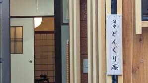 A traditional Japanese interior with tatami mats, a sliding door, and a sign with Japanese characters. - Dongurian (Kyoto)