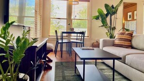 Een gezellige woonkamer met een bank, een salontafel en een eethoek met stoelen en een tafel.