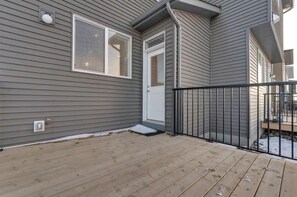 Enjoy an entrance and outdoor space with a deck and black railing.