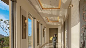 A hallway with a polished marble floor, large windows, and a ceiling with intricate designs. - Mementos By ITC Hotels Ekaaya Udaipur (Udaipur)