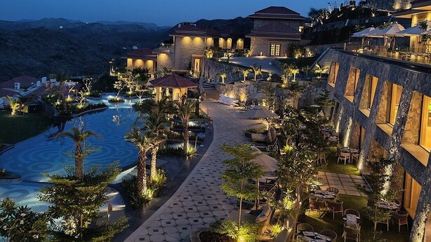 A resort with a pool, outdoor seating, and a view of the ocean at dusk. - Mementos By ITC Hotels Ekaaya Udaipur (Udaipur)
