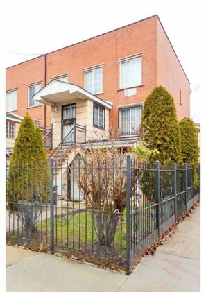 Stylish apartment building with a small porch and well-manicured lawn.