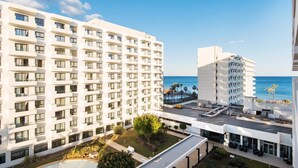 A modern hotel with multiple floors, a rooftop pool, and a view of the ocean. - Carihuela Beach Sun Private apartment (TORREMOLINOS)