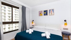 A hotel room with a large bed, two bedside tables, a window with curtains, and three wall-mounted lamps. - Carihuela Beach Sun Private apartment (TORREMOLINOS)