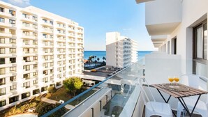 A modern hotel balcony with a glass railing overlooking a pool and a view of the ocean. - Carihuela Beach Sun Private apartment (TORREMOLINOS)