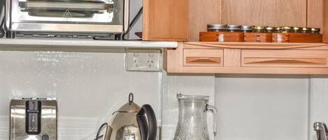 A kitchen with a toaster, a kettle, and a glass pitcher on the counter.