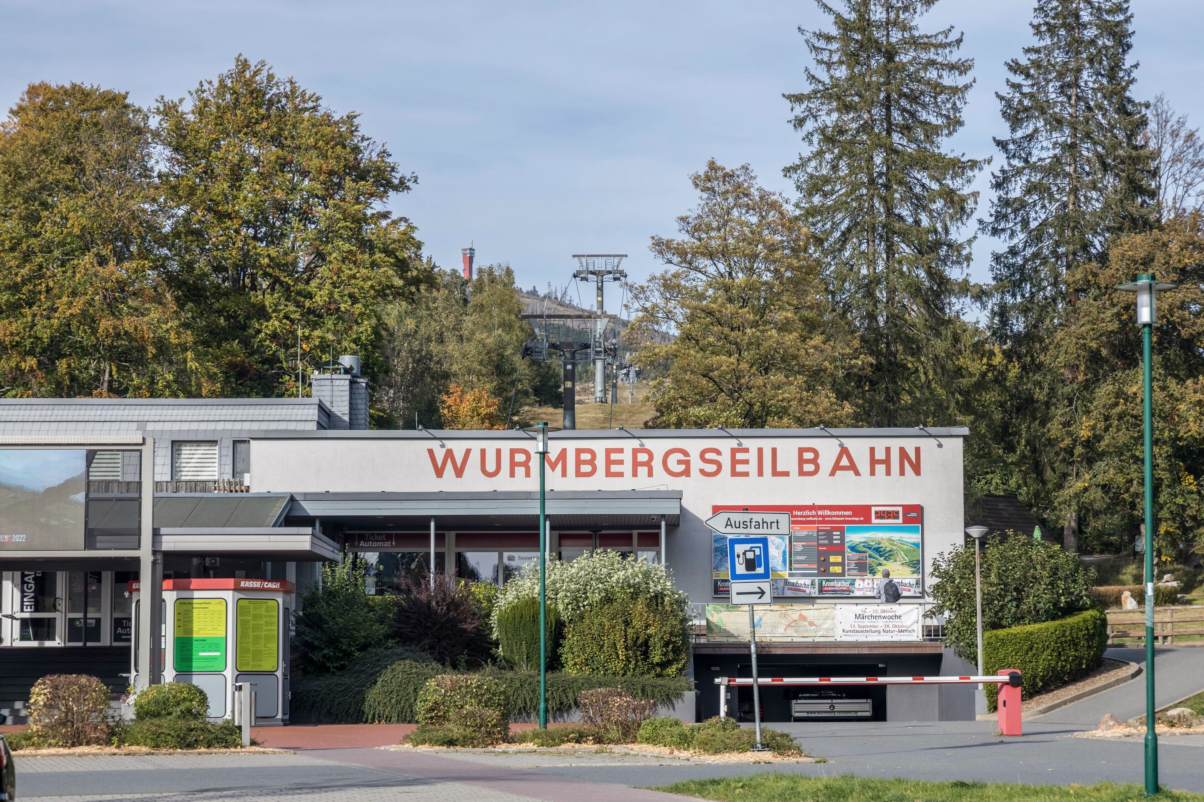 En byggnad med en skylt som visar texten ”WURMBERGSEILBAHN” och en vägvisningsskylt som pekar mot ”utgången”.