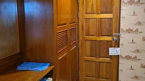 A room with a wooden wardrobe, a desk with a blue folder, and a door with a 'Please Clean the Room' sign. - Kamala Cool 2 (Kamala)