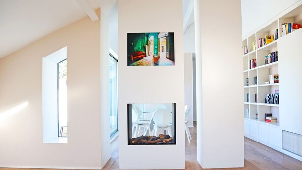 A spacious room with a wooden floor, a white bookshelf, and two framed artworks. - Castello Charme Style House (Milano)
