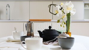 A table set with a teapot, cups, and a vase with orchids. - Castello Charme Style House (Milano)